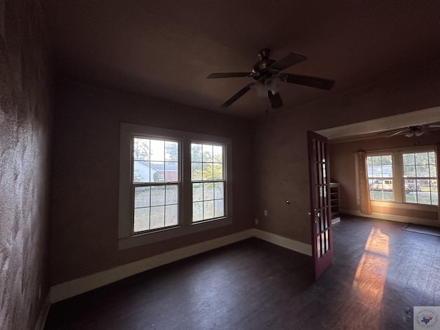 empty room with ceiling fan and dark hardwood / wood-style flooring