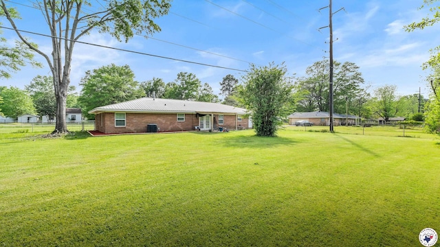 view of yard featuring central AC and fence