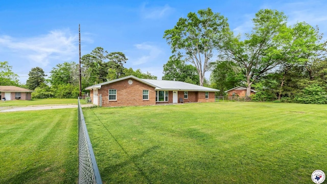 ranch-style home featuring fence, driveway, brick siding, and a front yard