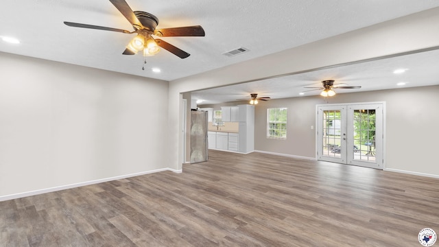 2401 E E Ave B, Hooks, TX 75561 - unfurnished living room with french doors, wood finished floors, baseboards, ceiling fan, and recessed lighting