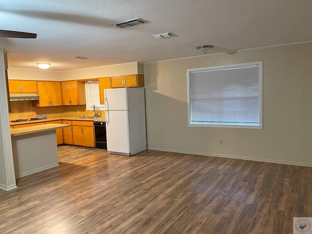 kitchen featuring a sink, black dishwasher, light countertops, freestanding refrigerator, and brown cabinets