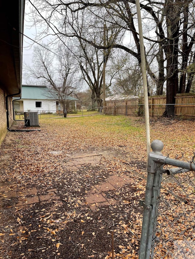 view of yard with fence and central AC