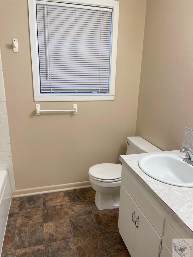 bathroom with baseboards, toilet, walk in shower, vanity, and a bath