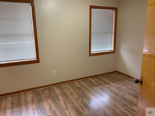 spare room with wood finished floors and baseboards