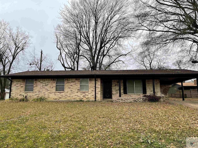 single story home with concrete driveway, an attached carport, a front lawn, and brick siding