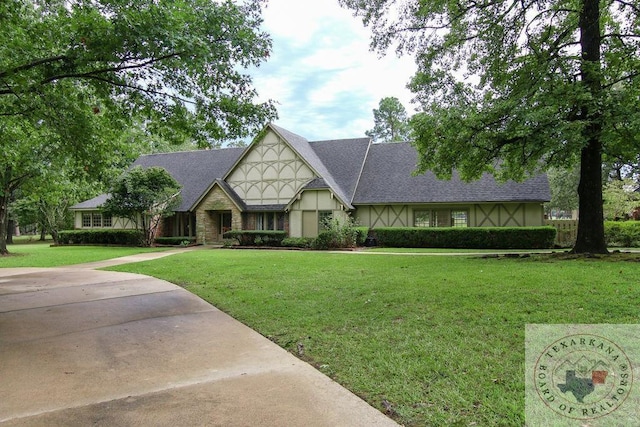 tudor home with a front lawn