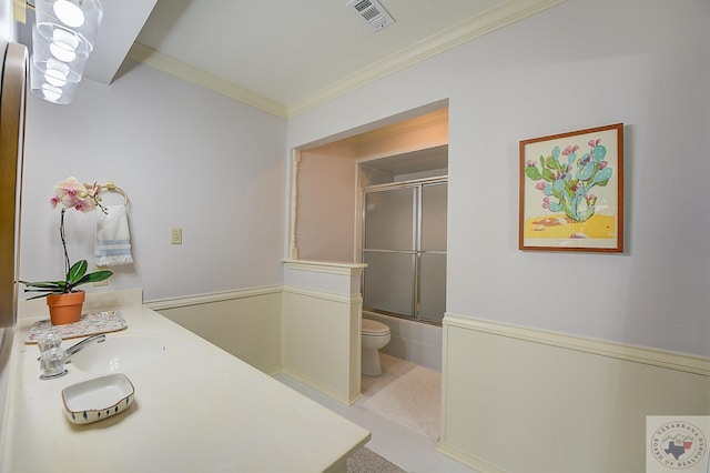 full bathroom featuring bath / shower combo with glass door, tile patterned flooring, ornamental molding, vanity, and toilet