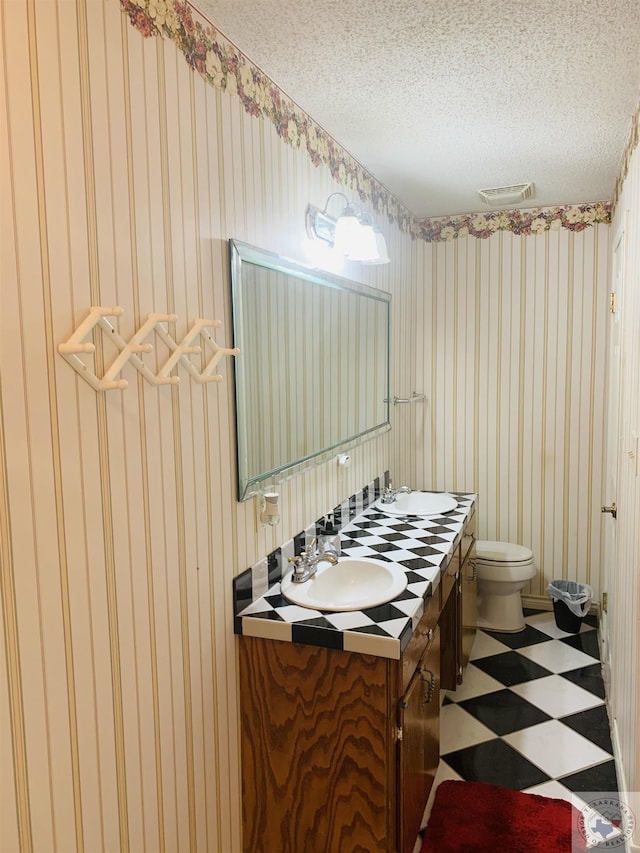 bathroom featuring vanity, toilet, and a textured ceiling