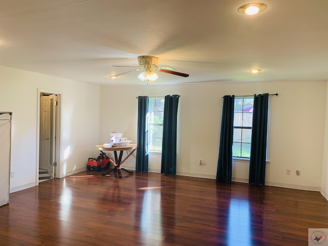 empty room with dark wood-type flooring and ceiling fan