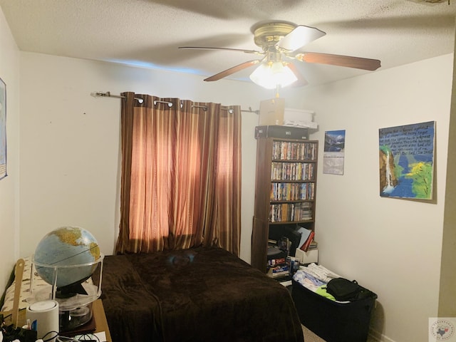 bedroom with ceiling fan and a textured ceiling