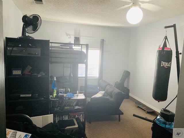 carpeted office space featuring ceiling fan and a textured ceiling