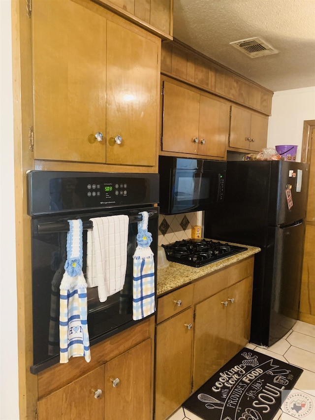 kitchen with backsplash, black appliances, a textured ceiling, and light tile patterned floors