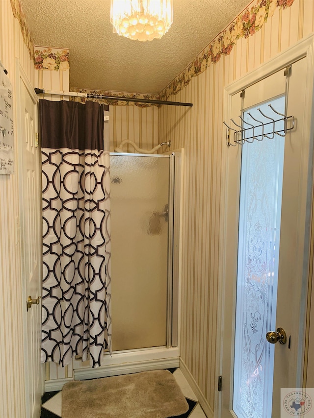 bathroom featuring wooden walls, a textured ceiling, and a shower