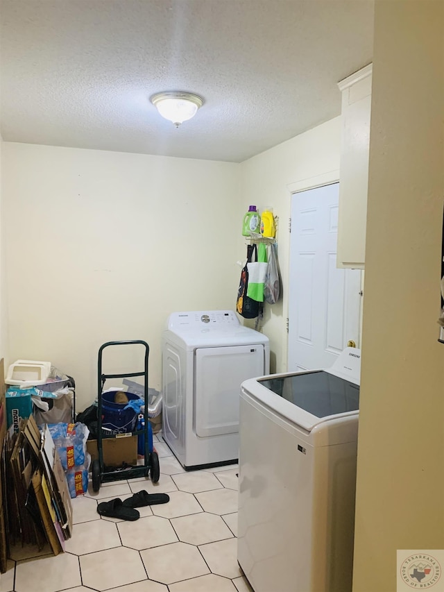 washroom featuring a textured ceiling and washing machine and dryer