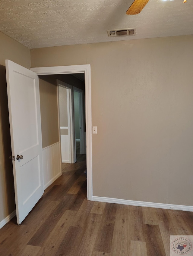 spare room with hardwood / wood-style floors, a textured ceiling, and ceiling fan