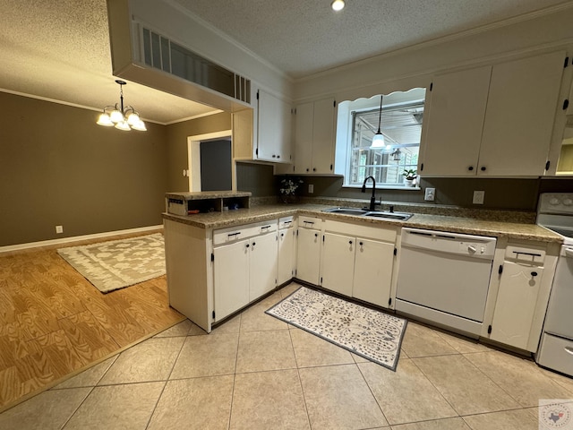 kitchen featuring sink, white cabinetry, white appliances, and hanging light fixtures