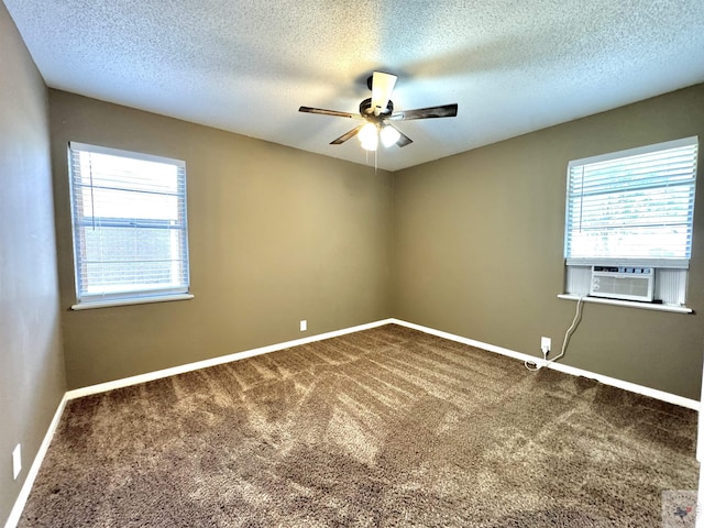 carpeted empty room featuring ceiling fan, a wealth of natural light, and a textured ceiling