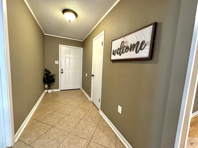 doorway with ornamental molding, light tile patterned floors, and a textured ceiling