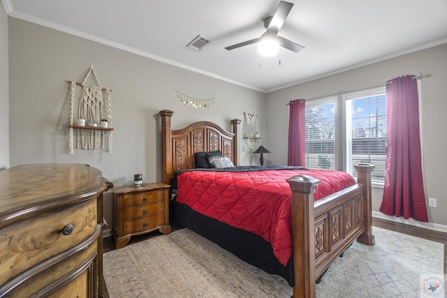 bedroom with light wood-style flooring, visible vents, baseboards, a ceiling fan, and ornamental molding