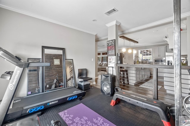 workout area with ornamental molding, visible vents, and baseboards