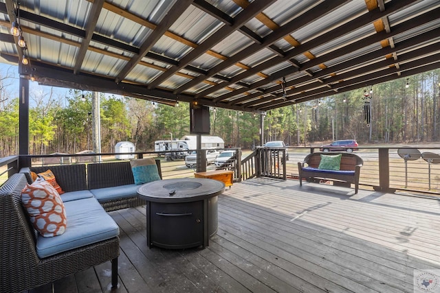 wooden deck with outdoor lounge area and a wooded view