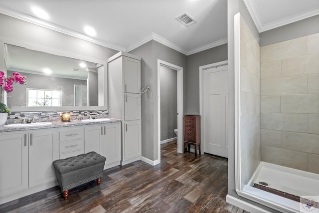 full bath with toilet, wood finished floors, a sink, visible vents, and ornamental molding