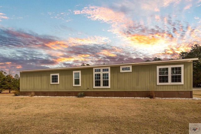 view of side of property with crawl space and a yard