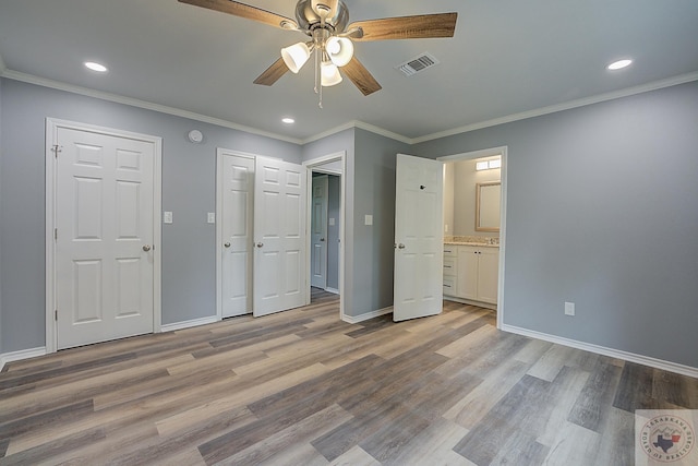 unfurnished bedroom featuring ceiling fan, light hardwood / wood-style flooring, ensuite bath, and crown molding