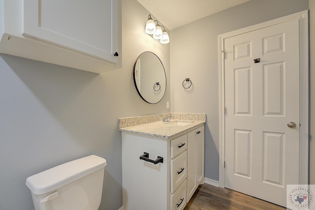 bathroom with hardwood / wood-style floors, toilet, and vanity