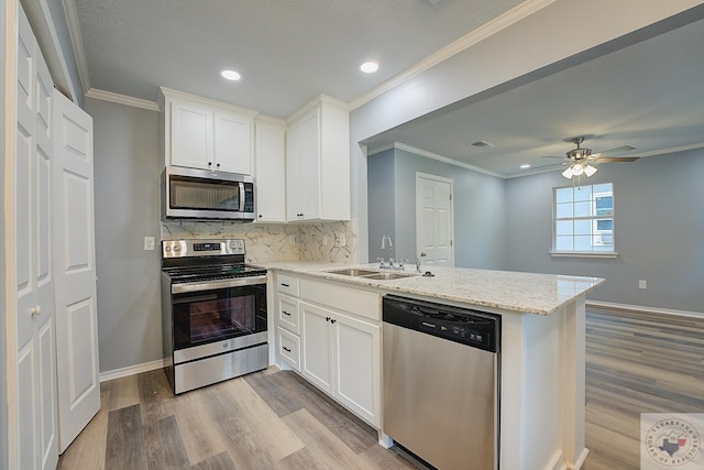 kitchen featuring sink, white cabinets, appliances with stainless steel finishes, and kitchen peninsula