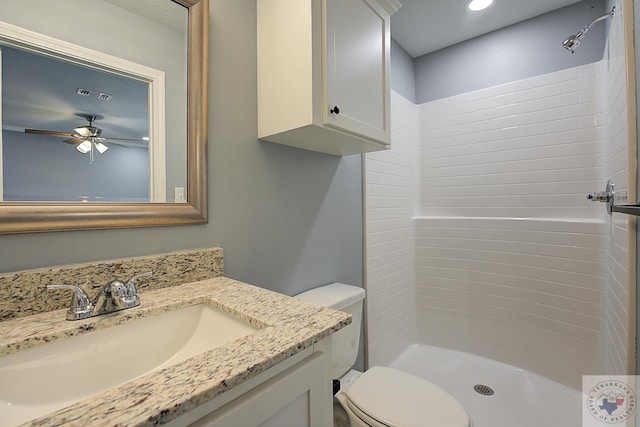 bathroom featuring vanity, toilet, a shower, and ceiling fan