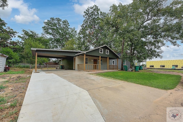 view of front facade featuring covered porch, a front yard, and a carport