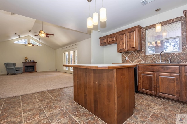 kitchen with plenty of natural light, a fireplace, dark colored carpet, and a sink