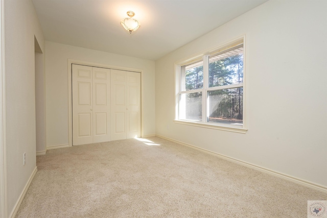 unfurnished bedroom with a closet, baseboards, and carpet floors