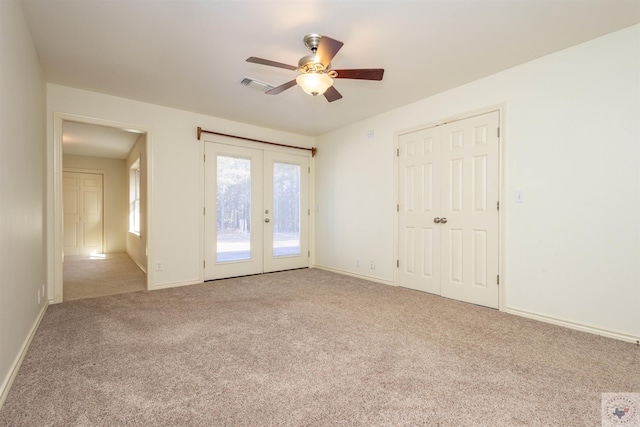 empty room with carpet, visible vents, french doors, and baseboards