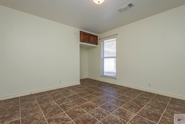 empty room with baseboards and visible vents