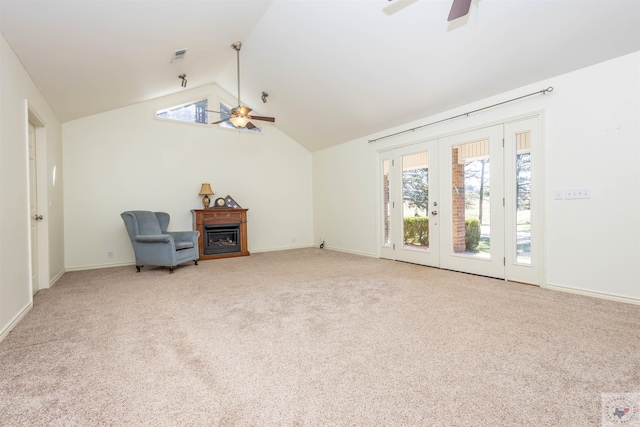 living area featuring lofted ceiling, a fireplace, carpet floors, and ceiling fan