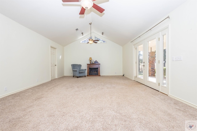 interior space featuring baseboards, ceiling fan, vaulted ceiling, carpet floors, and a fireplace