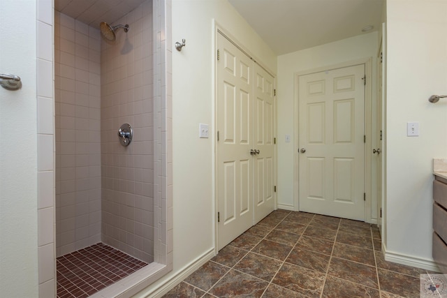 bathroom with baseboards, a stall shower, and vanity