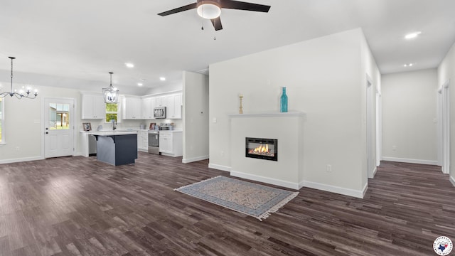 206 Spencer St, Maud, TX 75567 - unfurnished living room with a ceiling fan, dark wood finished floors, a chandelier, a glass covered fireplace, and recessed lighting