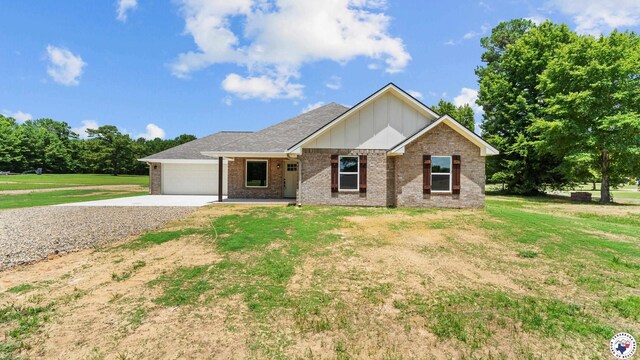 206 Spencer St, Maud, TX 75567 - single story home with board and batten siding, concrete driveway, brick siding, a front yard, and a garage
