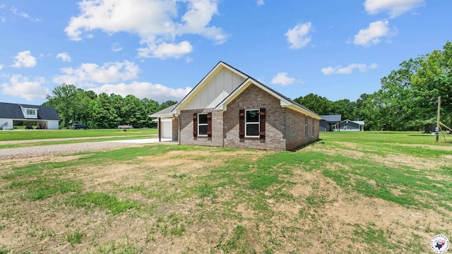 206 Spencer St, Maud, TX 75567 - view of front facade featuring board and batten siding, brick siding, a front lawn, driveway, and an attached garage