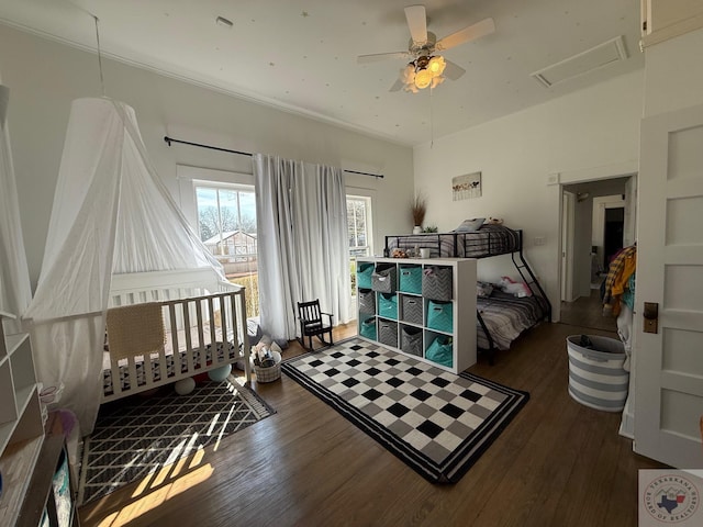 bedroom featuring ceiling fan, attic access, and wood finished floors