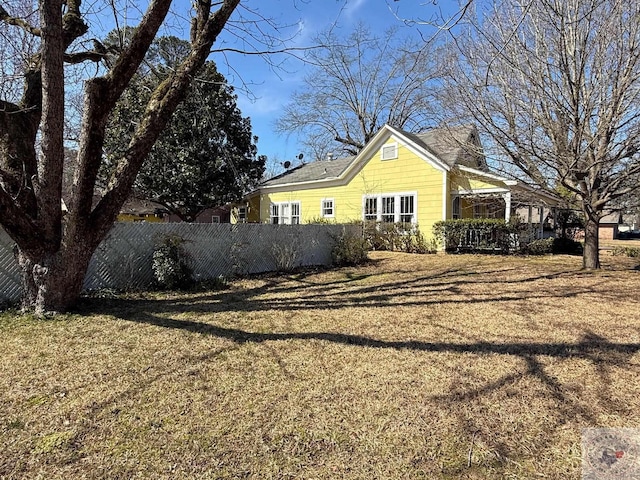 view of property exterior featuring a yard and fence