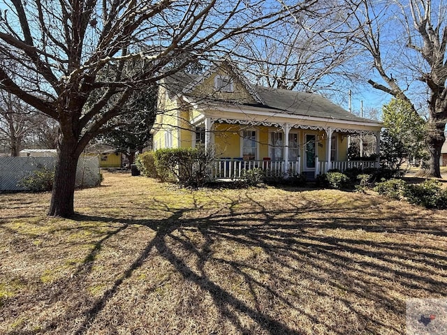 view of front of home featuring a porch and fence