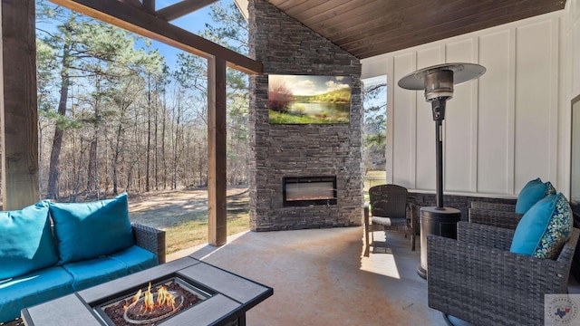 sunroom with wood ceiling, lofted ceiling, and an outdoor stone fireplace