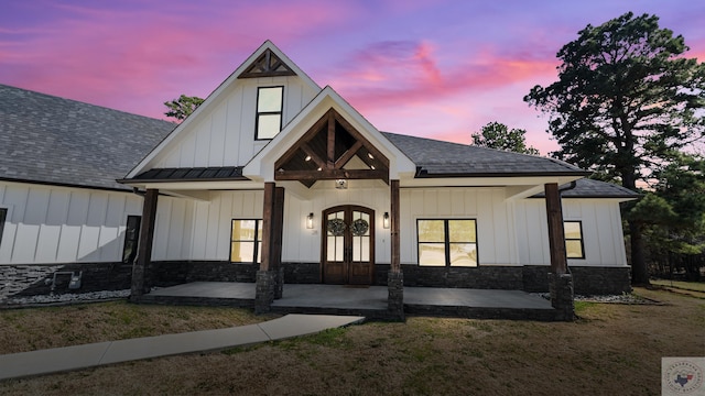 modern farmhouse style home with board and batten siding, french doors, roof with shingles, and stone siding