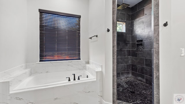 full bath featuring a garden tub and a tile shower