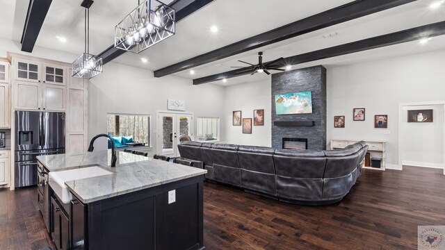 kitchen with a fireplace, a sink, open floor plan, french doors, and stainless steel fridge