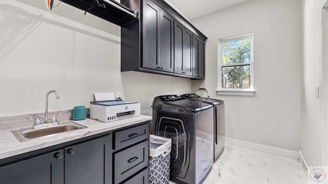 washroom with a sink, baseboards, marble finish floor, cabinet space, and washer and clothes dryer